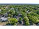 An aerial view of a neighborhood shows homes nestled within mature trees at 912 N Roux St, Plant City, FL 33563