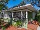 A well-maintained single-story home with a front porch surrounded by greenery and a brick trimmed entrance at 912 N Roux St, Plant City, FL 33563