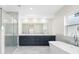 Bright bathroom features a double sink vanity, a modern bathtub, and a glass-enclosed shower at 1030 11Th S Ave, St Petersburg, FL 33705