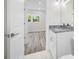Bathroom vanity and sink are visible with a partial view to a bedroom with hardwood floors and a window at 1030 11Th S Ave, St Petersburg, FL 33705