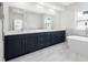 Bathroom boasts a double sink vanity, a large mirror, and a modern bathtub with bright natural light at 1030 11Th S Ave, St Petersburg, FL 33705