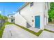 Exterior view of a modern home with a blue front door, attached garages and landscaped yard at 1030 11Th S Ave, St Petersburg, FL 33705