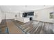 Open-concept kitchen featuring gray wood floors, modern cabinetry, stainless steel appliances, and a central island, perfect for entertaining at 1030 11Th S Ave, St Petersburg, FL 33705