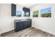 This kitchenette features gray cabinets, granite countertop, stainless faucet, and wood-look floors, with natural light streaming through windows at 1030 11Th S Ave, St Petersburg, FL 33705