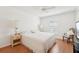 Bright bedroom featuring a ceiling fan, white bedding, hardwood floors, and a large window at 10530 Maronda Dr, Riverview, FL 33569