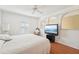 Bedroom showcasing white walls, hardwood floors, plantation shutters, a ceiling fan, and television at 10530 Maronda Dr, Riverview, FL 33569