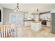 Open kitchen and breakfast area with an island, white cabinetry, and stainless steel appliances at 10530 Maronda Dr, Riverview, FL 33569