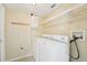Laundry room with a white washer and dryer, a shelf, and wall-mounted storage features at 10530 Maronda Dr, Riverview, FL 33569