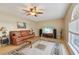 Cozy living room with neutral walls, ceiling fan, plush rug, and a large picture window at 10530 Maronda Dr, Riverview, FL 33569