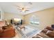 Comfortable living room featuring neutral walls, a ceiling fan, a plush rug, and natural light at 10530 Maronda Dr, Riverview, FL 33569