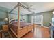 Main bedroom suite features wood flooring, a four-poster bed, and an airy, sunlit ambiance at 10530 Maronda Dr, Riverview, FL 33569