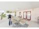 Covered patio with dining set, grill, and double doors leading inside the home at 10530 Maronda Dr, Riverview, FL 33569