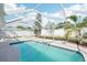 Screened-in pool with waterfall feature and jacuzzi, surrounded by a well-maintained patio at 10530 Maronda Dr, Riverview, FL 33569