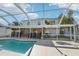 Backyard view of screened pool with a large two story home in the background at 10530 Maronda Dr, Riverview, FL 33569