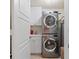 Convenient laundry room with stacked washer and dryer, storage cabinets, a sink, and neutral tile flooring at 11 Baymont St # 1109, Clearwater Beach, FL 33767