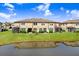 Townhome complex features a beautiful pond view, and a well-manicured lawn at 11521 Crowned Sparrow Ln, Tampa, FL 33626