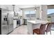 Bright modern kitchen featuring stainless steel appliances, white cabinetry, and a cozy breakfast bar at 11521 Crowned Sparrow Ln, Tampa, FL 33626