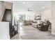 Open-concept living space with wood-look tile, staircase, plush sectional and a ceiling fan at 11521 Crowned Sparrow Ln, Tampa, FL 33626