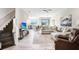 Open-concept living space with wood-look tile, staircase, plush sectional and a ceiling fan at 11521 Crowned Sparrow Ln, Tampa, FL 33626