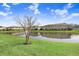 Scenic view of a community pond reflecting the townhomes under a blue sky with clouds at 11521 Crowned Sparrow Ln, Tampa, FL 33626