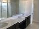 Bathroom featuring double sinks, dark cabinetry, and a large mirror at 11624 Fringetree Ct, Riverview, FL 33579