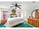 Bright bedroom features a ceiling fan, a large bed and wooden furniture at 12501 Ulmerton Rd # 133, Largo, FL 33774