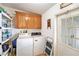 Well-equipped laundry room with storage cabinets, washer, dryer, and an exterior door at 12501 Ulmerton Rd # 133, Largo, FL 33774