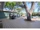 Backyard featuring a large deck, swimming pool, and mature shade tree at 126 Orangewood Dr, Dunedin, FL 34698