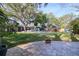 Spacious backyard with a pool, lush lawn, patio, and seating area, ideal for outdoor relaxation and entertainment at 126 Orangewood Dr, Dunedin, FL 34698