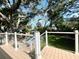Expansive backyard featuring a sparkling pool, lush lawn, mature trees, and a view of the water at 126 Orangewood Dr, Dunedin, FL 34698