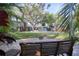 Secluded backyard featuring a pool, well-manicured lawn, mature trees, and a patio with bench seating at 126 Orangewood Dr, Dunedin, FL 34698
