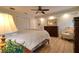 Cozy bedroom featuring a ceiling fan, wood floors, and a quaint sitting area with a comfortable armchair at 126 Orangewood Dr, Dunedin, FL 34698