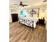 The main bedroom features hardwood floors, a large ceiling fan, a wrought iron bed and bedside tables at 126 Orangewood Dr, Dunedin, FL 34698