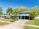 Lovely home with a spacious driveway, portico, mature landscaping, and a freshly cut lawn at 126 Orangewood Dr, Dunedin, FL 34698