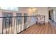 Hallway with wood floor, metal railing, and artwork hanging on the wall at 126 Orangewood Dr, Dunedin, FL 34698