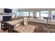 Spacious kitchen island with marble countertop and stainless steel sink, connecting to a living room with fireplace at 126 Orangewood Dr, Dunedin, FL 34698
