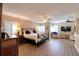View of a large main bedroom with wood floors, ceiling fans, plantation shutters, and neutral walls at 126 Orangewood Dr, Dunedin, FL 34698