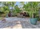 Secluded backyard brick patio features lush landscaping and a peaceful ambiance, perfect for outdoor relaxation at 126 Orangewood Dr, Dunedin, FL 34698