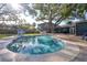 A private in-ground swimming pool surrounded by a travertine tile patio at 126 Orangewood Dr, Dunedin, FL 34698