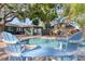 Inviting backyard featuring a sparkling swimming pool and lounge area under mature trees at 126 Orangewood Dr, Dunedin, FL 34698