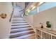 Stairway with stained wood steps, white risers, and natural light at 126 Orangewood Dr, Dunedin, FL 34698