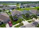 Aerial view of a well-maintained home with a manicured lawn and inviting curb appeal, surrounded by lush landscaping and palm trees at 13113 Rain Lily Dr, Riverview, FL 33579