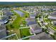 Community aerial view featuring a beautiful pond and well-maintained homes, each with lush landscaping and inviting yards at 13113 Rain Lily Dr, Riverview, FL 33579
