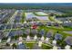 Stunning aerial view of the community showcasing houses, a large pond, mature landscaping, and street layout at 13113 Rain Lily Dr, Riverview, FL 33579