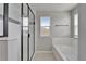 Modern bathroom highlighting a glass-enclosed shower, a soaking tub, and abundant natural light at 13113 Rain Lily Dr, Riverview, FL 33579