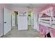 Bright bedroom featuring a castle-themed bunk bed, shelves and access to additional rooms at 13113 Rain Lily Dr, Riverview, FL 33579