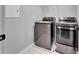 Modern laundry room featuring a gray front-load washing machine and dryer set at 13113 Rain Lily Dr, Riverview, FL 33579
