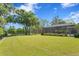 View of the large backyard, including covered lanai, a play area, lush lawn, and mature trees at 16119 Carencia Ln, Odessa, FL 33556