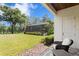 View of the backyard and screened in patio, with lush green lawn and mature trees on a sunny day at 16119 Carencia Ln, Odessa, FL 33556