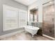 Bathroom with clawfoot tub, walk-in shower, and neutral-toned tile floor at 16119 Carencia Ln, Odessa, FL 33556